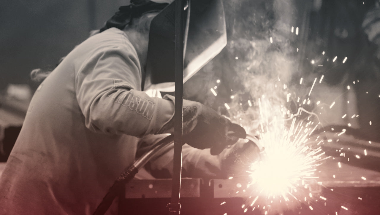 person welding with hood on